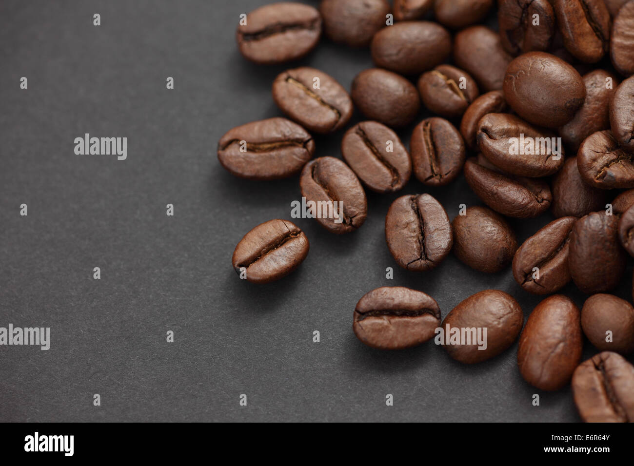 Chicchi di caffè nero su sfondo della carta Foto Stock