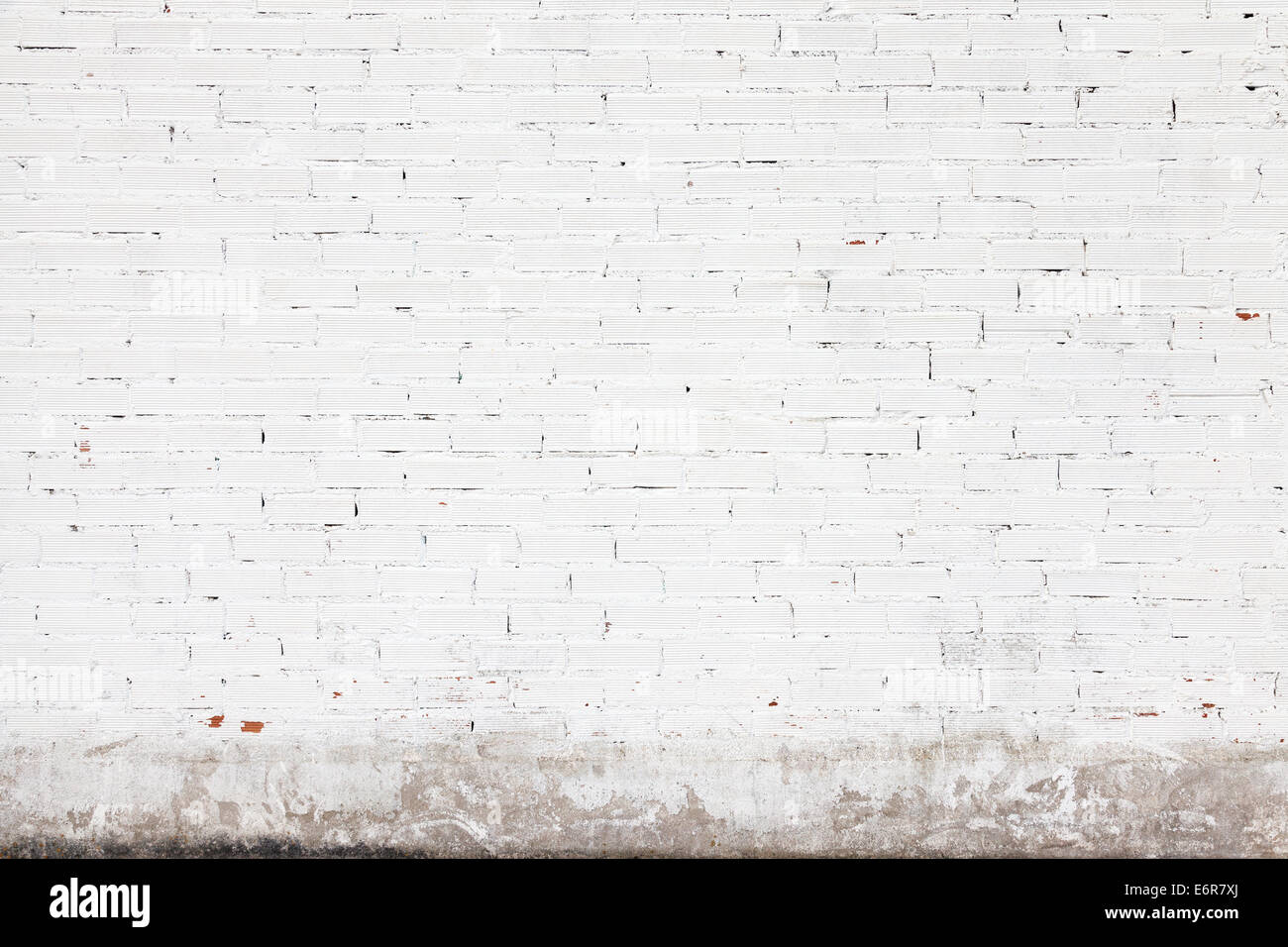 Muro Bianco texture di sfondo con mattoni e crepe su stucco Foto Stock