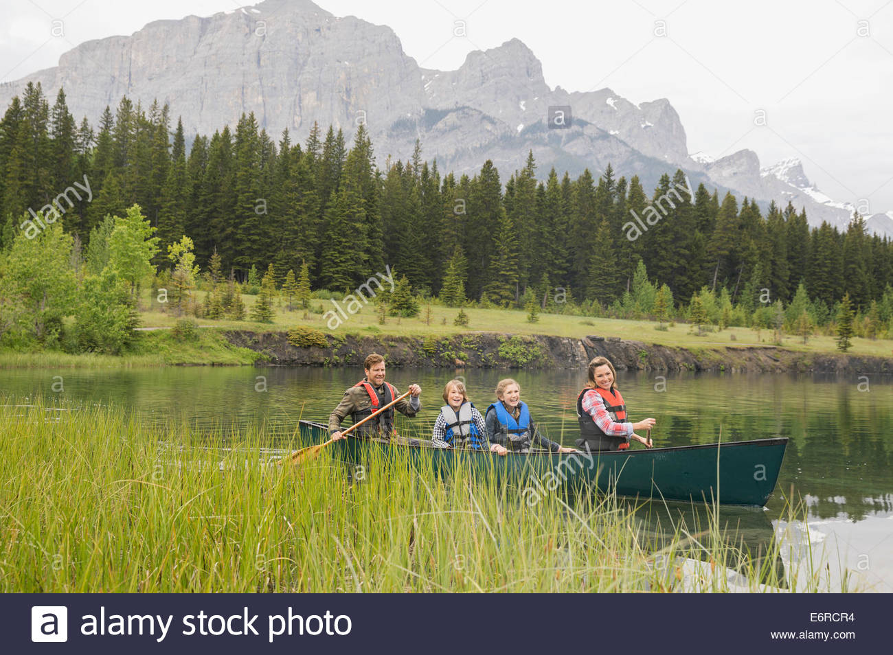 Famiglia di canoa a remi nel lago ancora Foto Stock