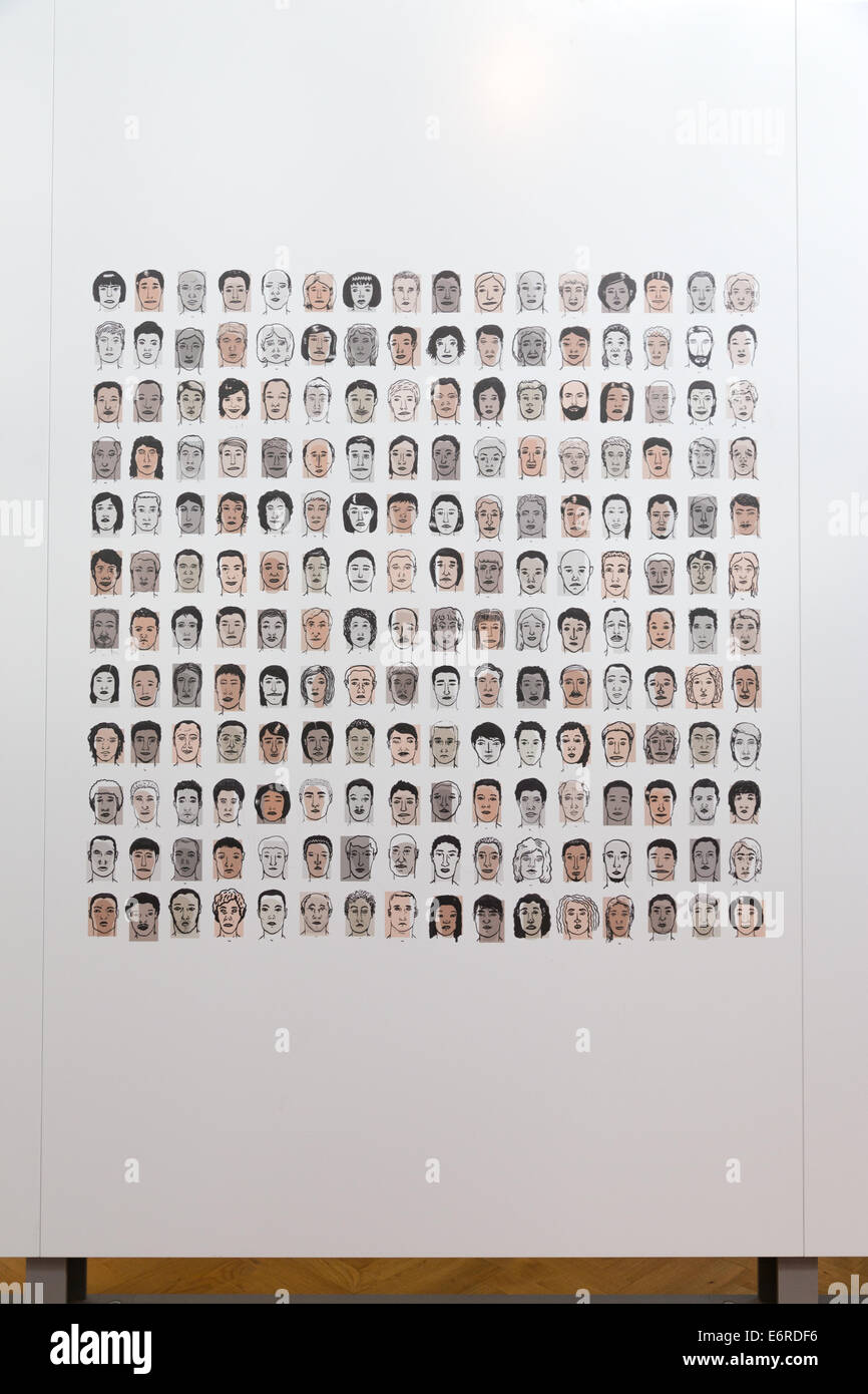 Disegni di diverse razze umane si affaccia su una parete bianca. In verticale Foto Stock