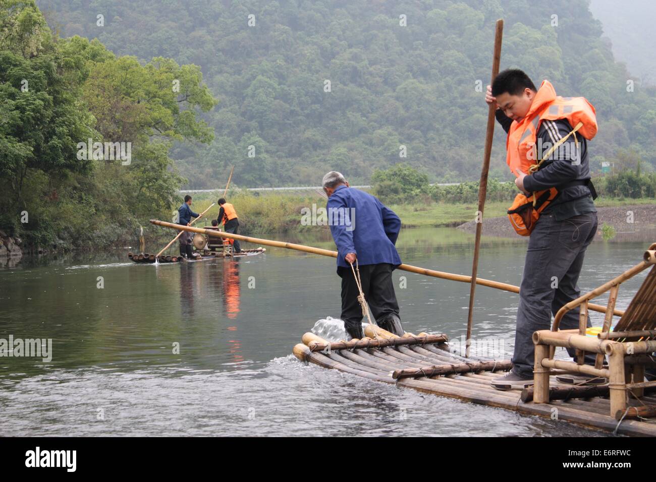 I pescatori locali portano i turisti su una zattera di bamboo crociera lungo il fiume Yulong in Cina Foto Stock