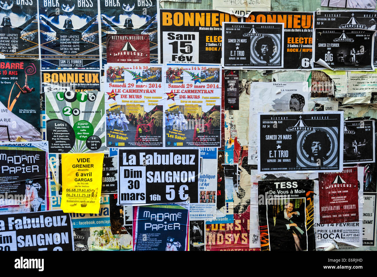 Le serrande di un abbandonato negozio francese, coperto con manifesti pubblicità concerti e le vendite Foto Stock