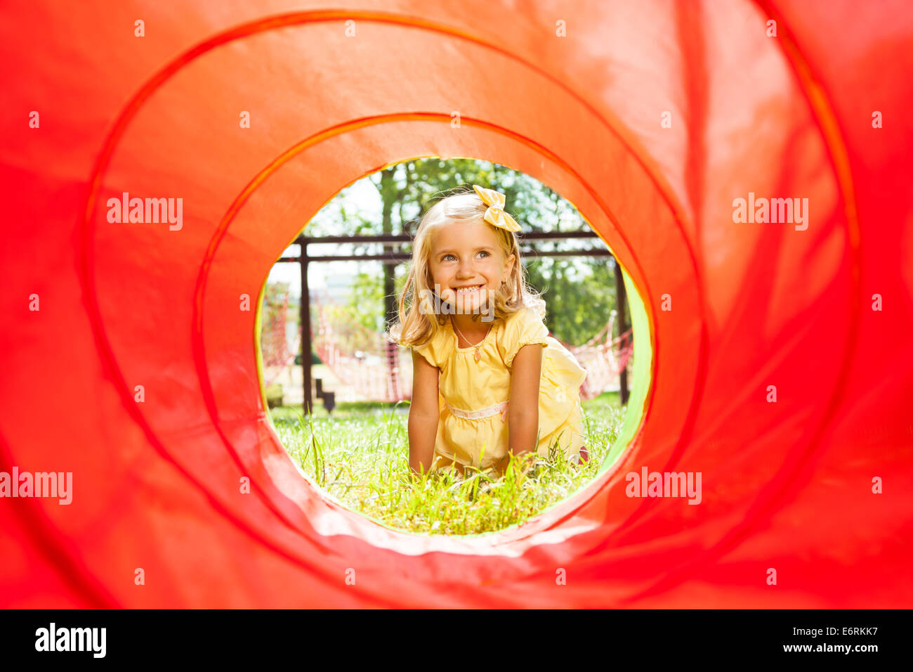 Bionda bella ragazza strisciando attraverso il tubo Foto Stock