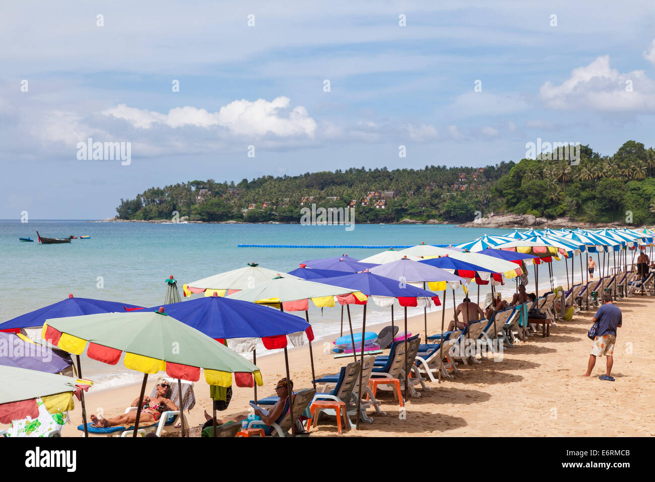 Colorato ombrelloni da spiaggia, ombrelloni, ombrelloni e sedie a sdraio in riva al mare nella spiaggia di Surin, Pkuket, Thailandia Foto Stock