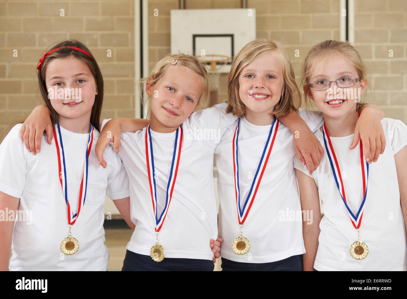 Scuola femminile sport di squadra in palestra con medaglie Foto Stock