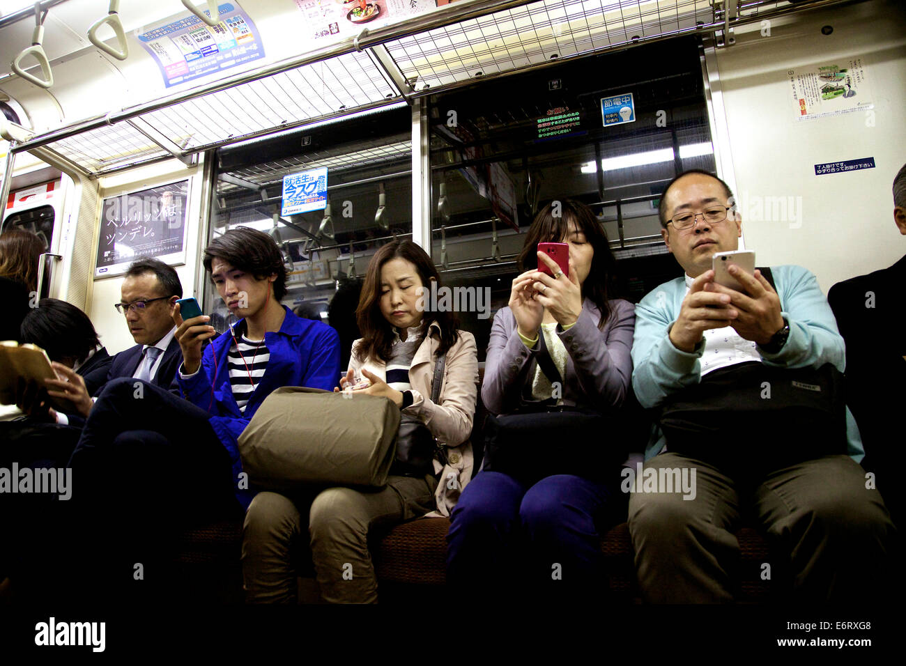 Persone giapponesi e pendolari che viaggiano sulla metropolitana con telefono cellulare, telefono, smartphone per Internet ed e-mail. Tokyo, Giappone, Asia Foto Stock