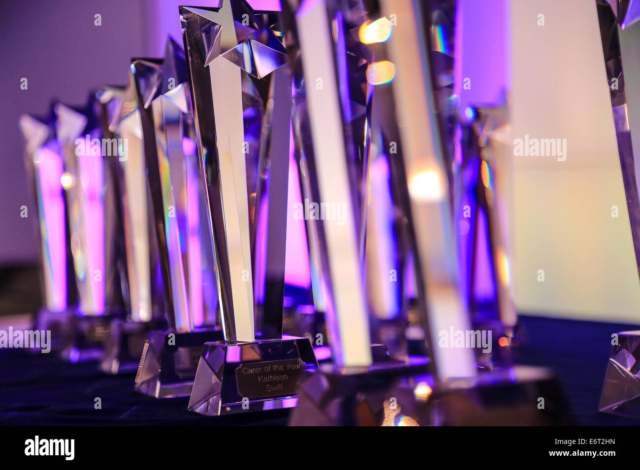 Premi di vetro/Trophy schierate prima della gioventù e cultura la premiazione a Liverpool con illuminazione colorata da dietro. Foto Stock