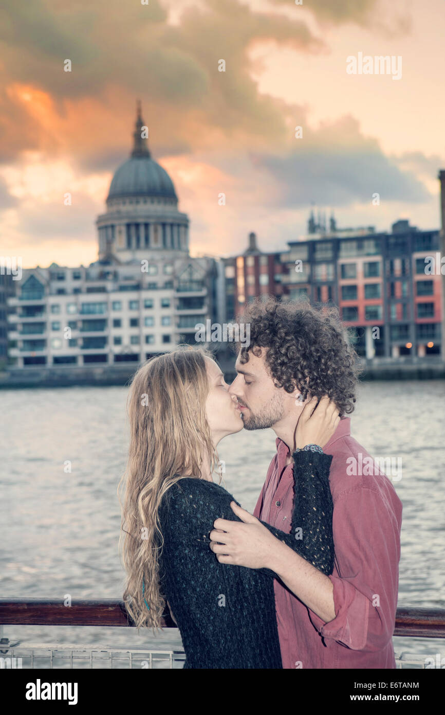 Una giovane coppia baciare in parte anteriore del Tamigi e la cattedrale di St Paul Foto Stock