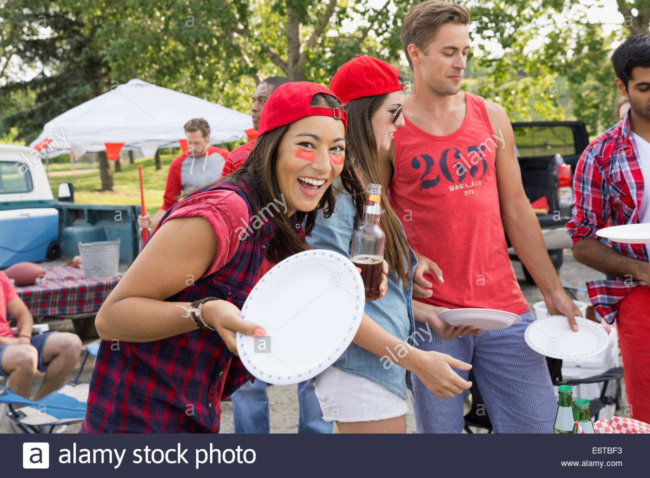Donna tenendo la piastra al portellone barbecue nel campo Foto Stock