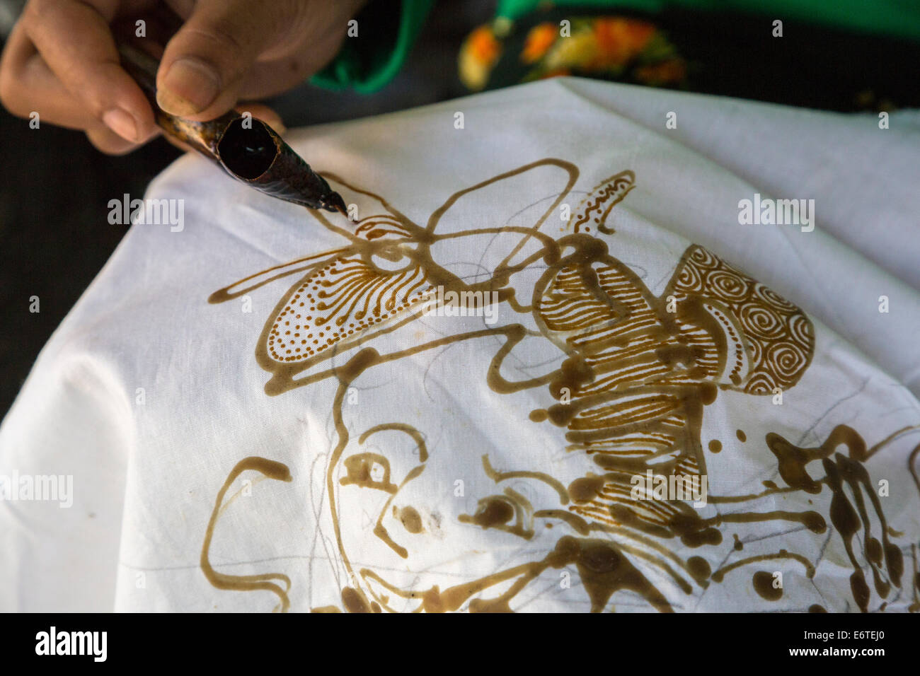 Yogyakarta, Java, Indonesia. La produzione di batik. Donna con cera calda per delineare un disegno su un panno Batik. Foto Stock