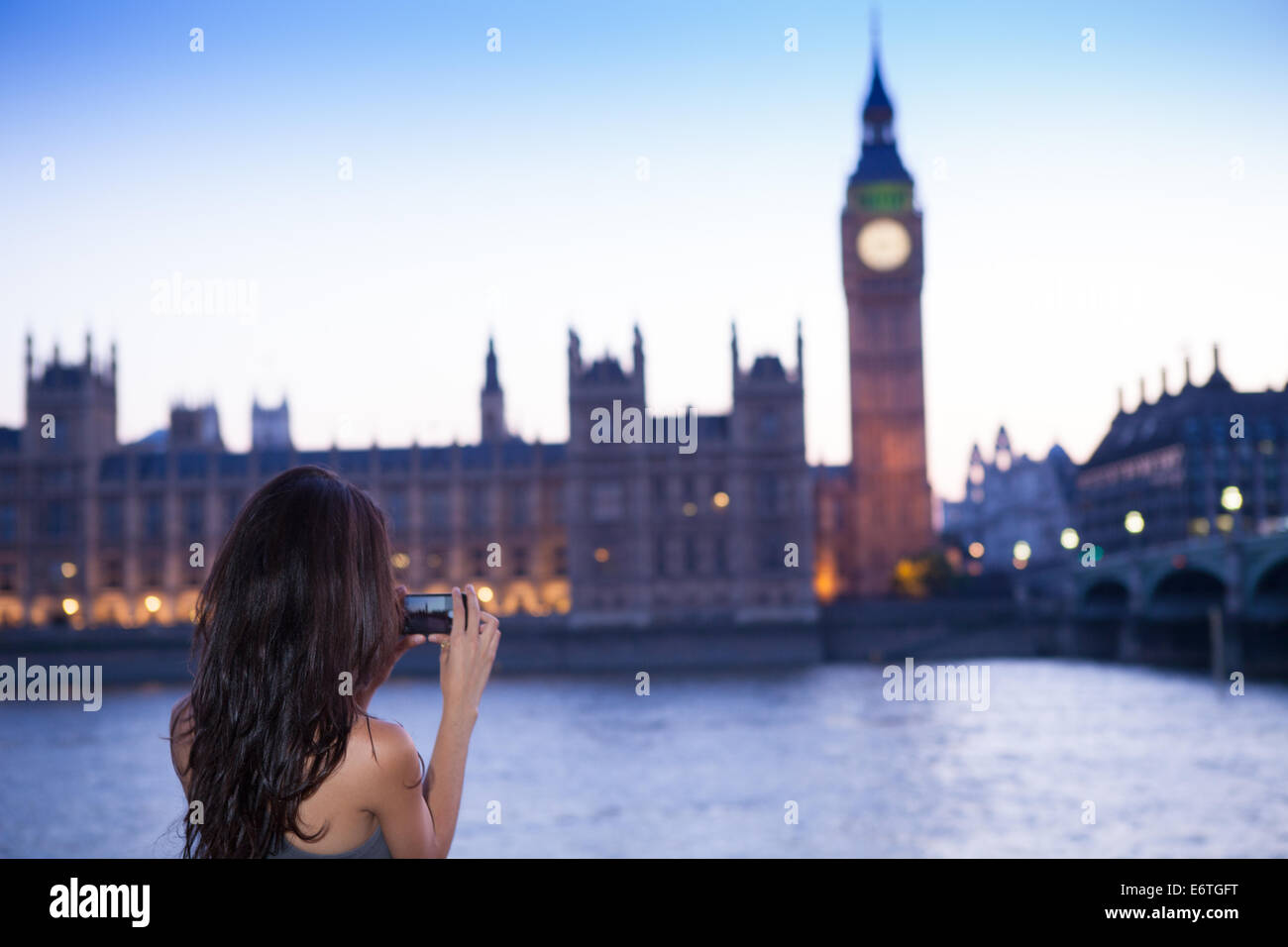 Una giovane donna di scattare una foto del Big Ben al crepuscolo Foto Stock