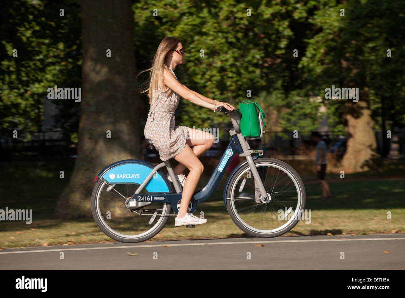 Una ciclista donna su un noleggio pubblico 'Boris bike' in un parco di Londra - il servizio pubblico di noleggio biciclette di Londra, Hyde Park, Londra, Regno Unito Foto Stock
