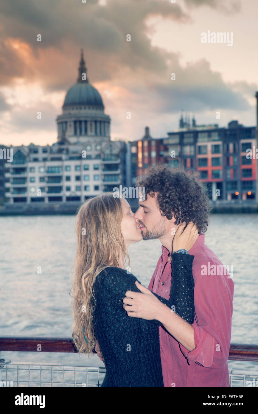 Una giovane coppia baciare in parte anteriore del Tamigi e Cattedrale di Saint Paul, Londra Foto Stock