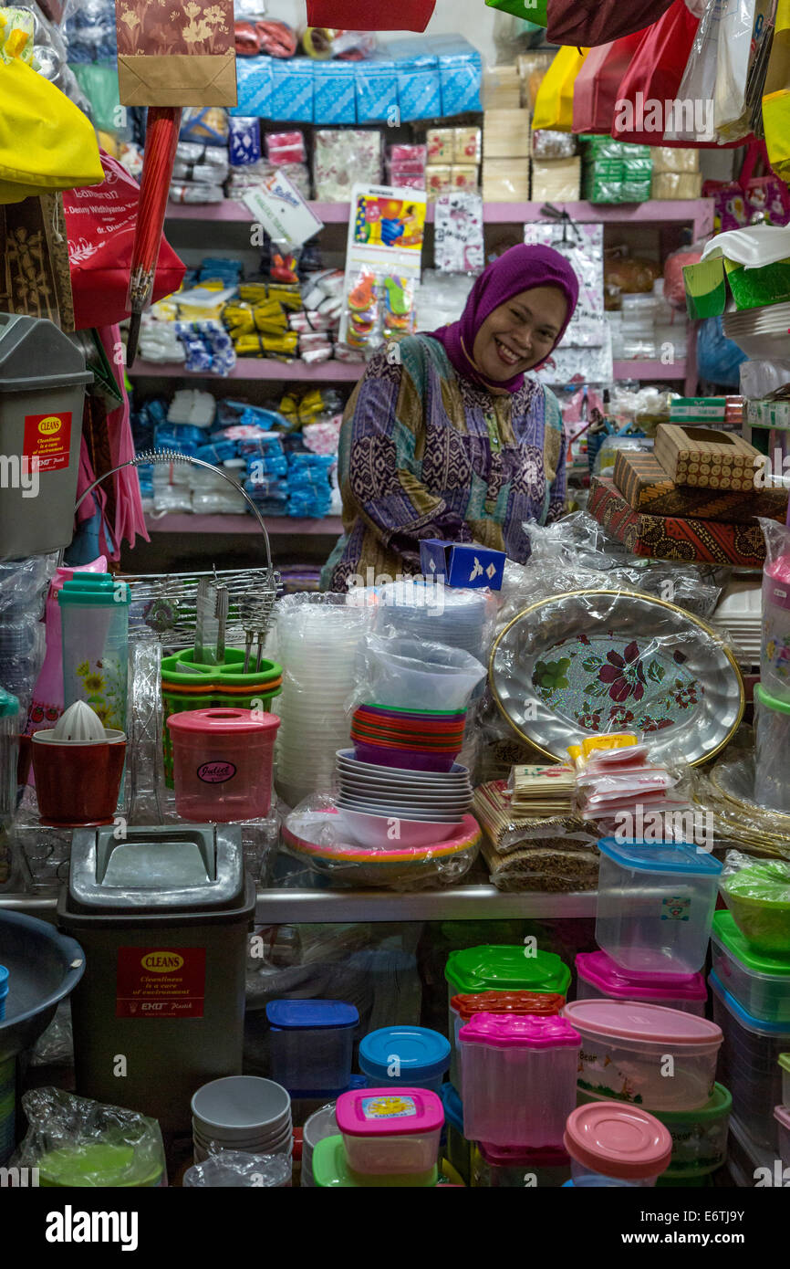 Yogyakarta, Java, Indonesia. Donna vendita di utensili domestici e piccole forniture, Beringharjo mercato. Foto Stock