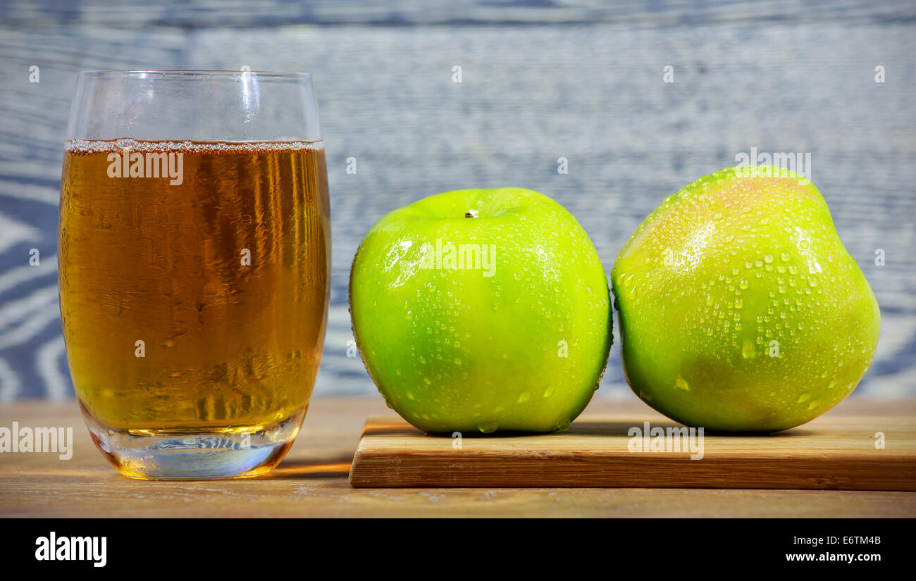 Freschi di succo di mela e frutti maturi contro lo sfondo di legno Foto Stock