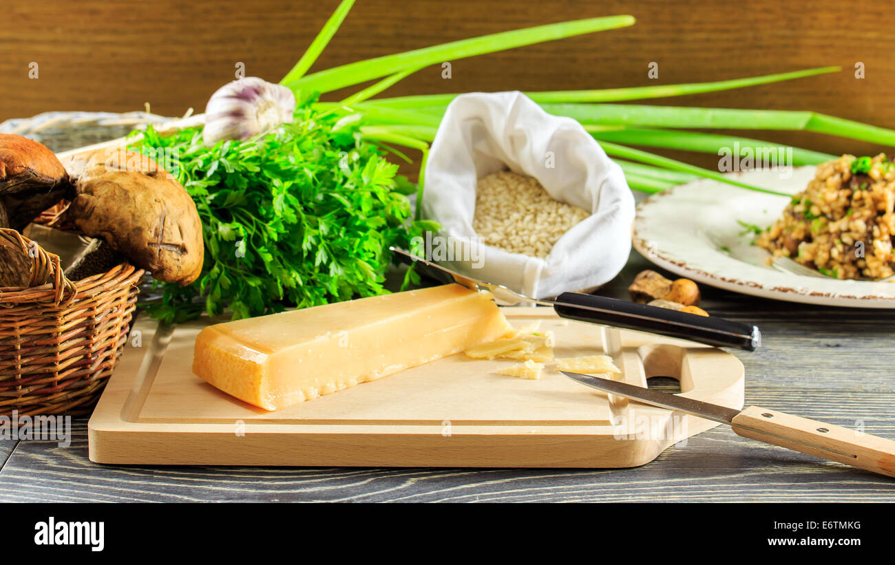 Gli ingredienti di italiano il risotto con funghi disposti su una tavola di legno Foto Stock