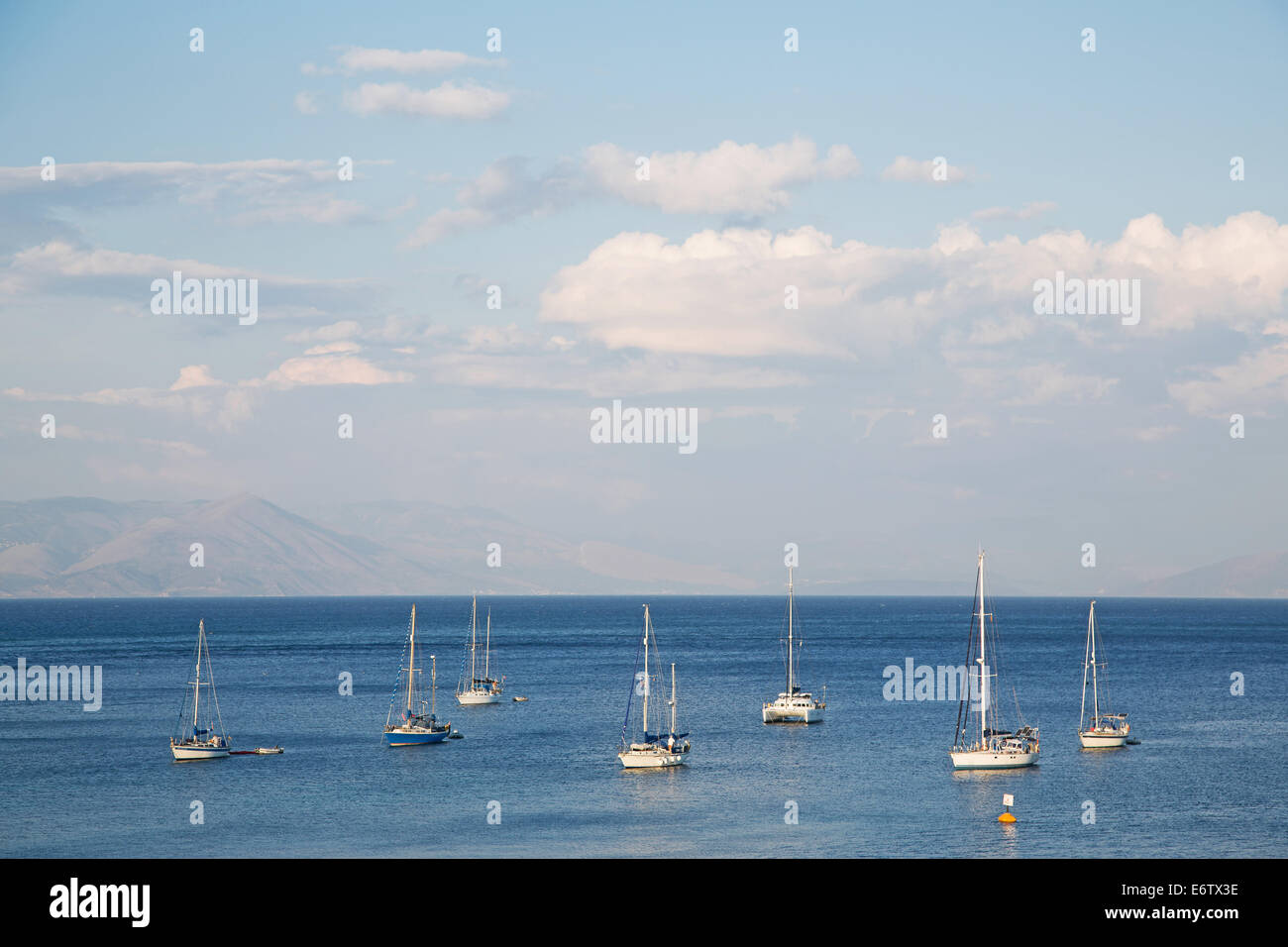 Acqua blu cielo e sullo sfondo il mare con le barche a vela in vacanza. Foto Stock
