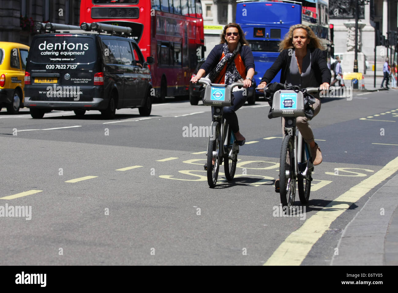 Due ciclisti femmina a cavallo, lungo una strada di Londra Foto Stock