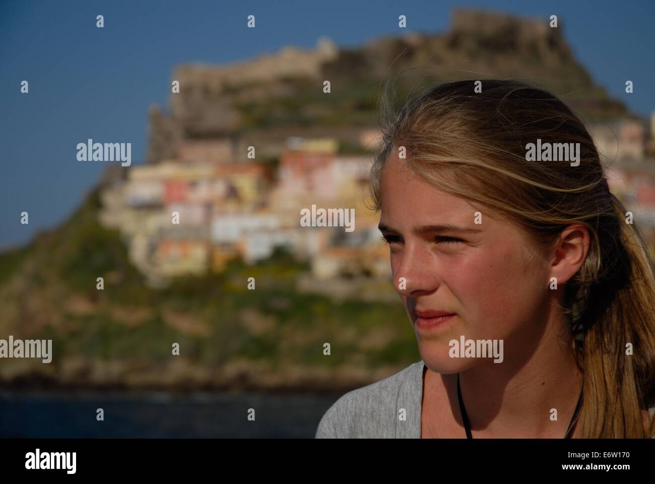 Ritratto di una ragazza e la vista su Castel Sardo in Sardegna in Italia Foto Stock