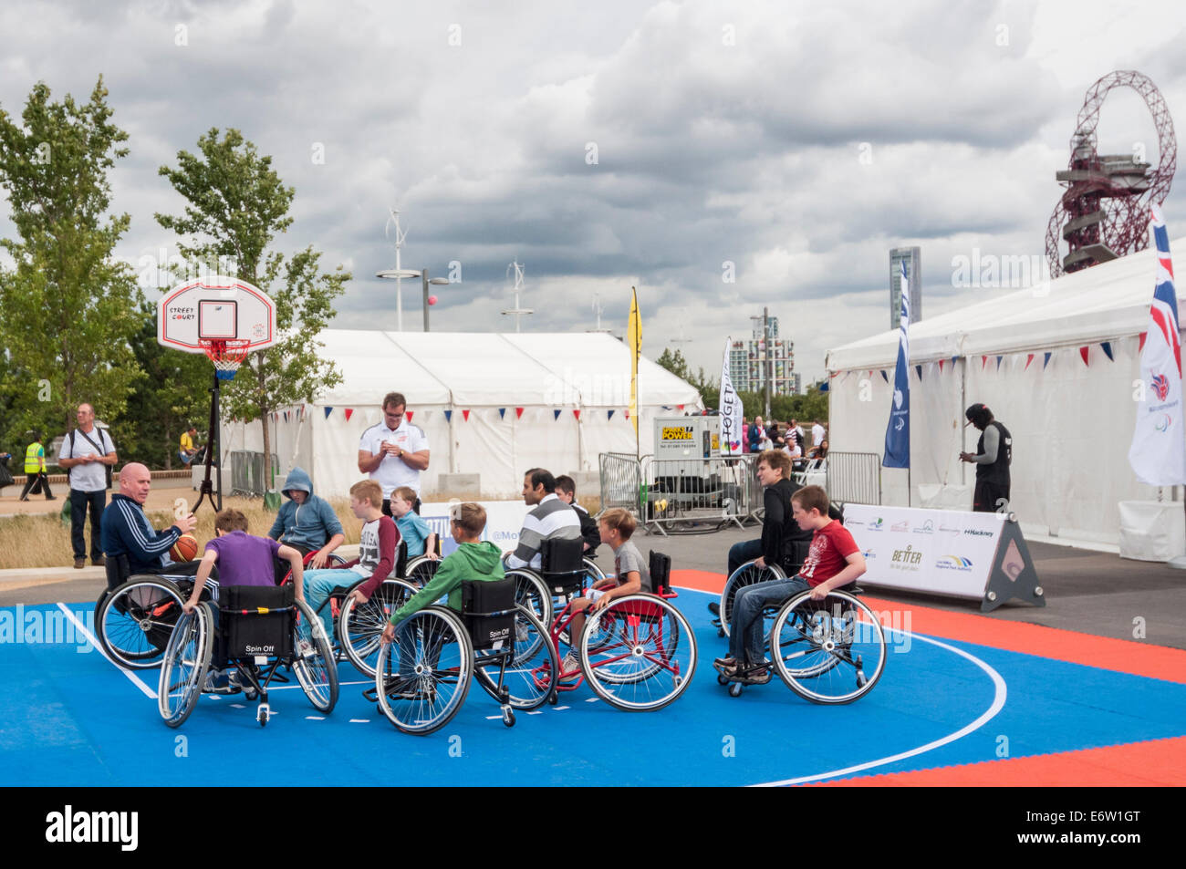 Stratford, Londra, UK, 30 agosto 2014. Il sindaco di Londra Festival Liberty, parte del National Paralympic Day 2014 presso la Queen Elizabeth Olympic Park, presentato la disabilità arti e inclusive sport. Nella foto : bambini di essere insegnato come basket in carrozzella. Credito: Stephen Chung/Alamy Live News Foto Stock