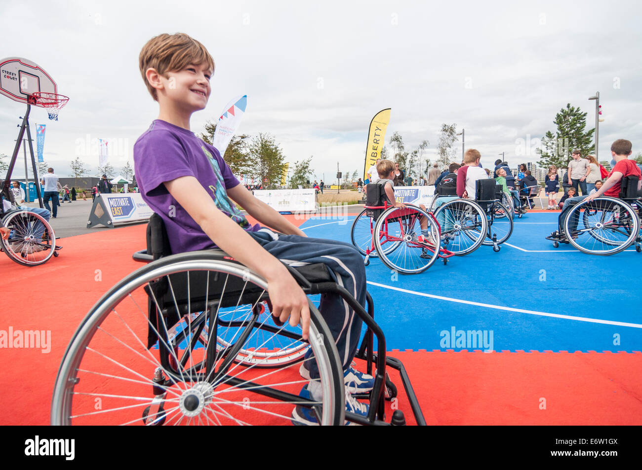 Stratford, Londra, UK, 30 agosto 2014. Il sindaco di Londra Festival Liberty, parte del National Paralympic Day 2014 presso la Queen Elizabeth Olympic Park, presentato la disabilità arti e inclusive sport. Nella foto : bambini di essere insegnato come basket in carrozzella. Credito: Stephen Chung/Alamy Live News Foto Stock
