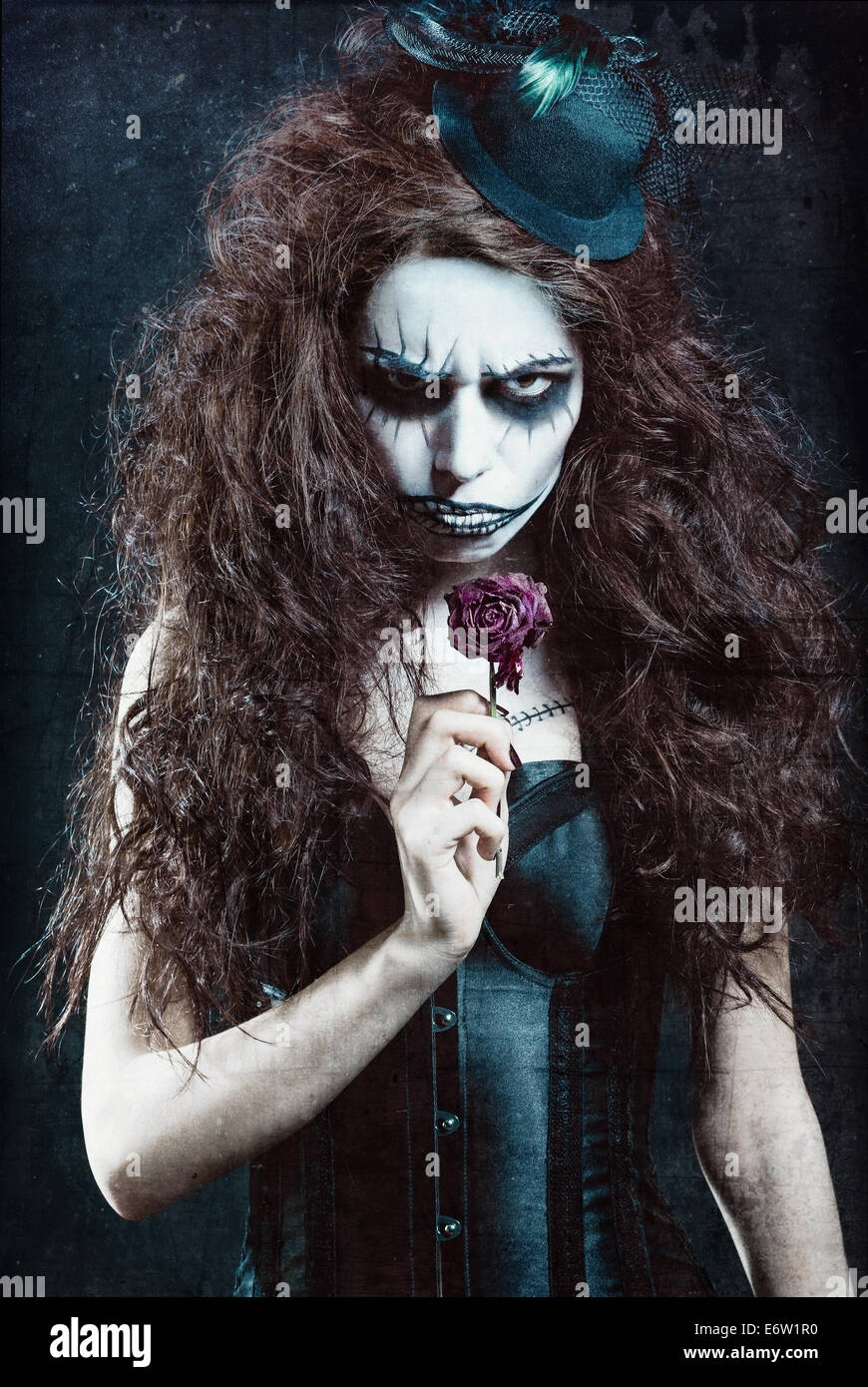 Donna in immagine di un palazzo gotico freak clown con fiori appassiti. Grunge effetto texture Foto Stock