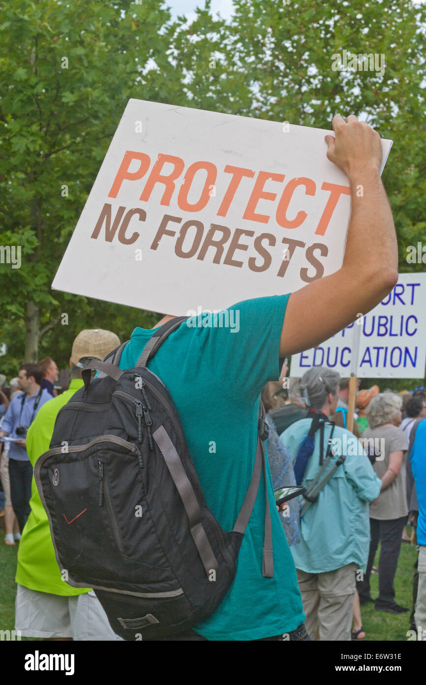 Asheville, North Carolina, Stati Uniti - 4 agosto 2014: L'uomo a un raduno morale del lunedì reca un cartello che dice "Proteggi foreste NC" in mezzo a Foto Stock