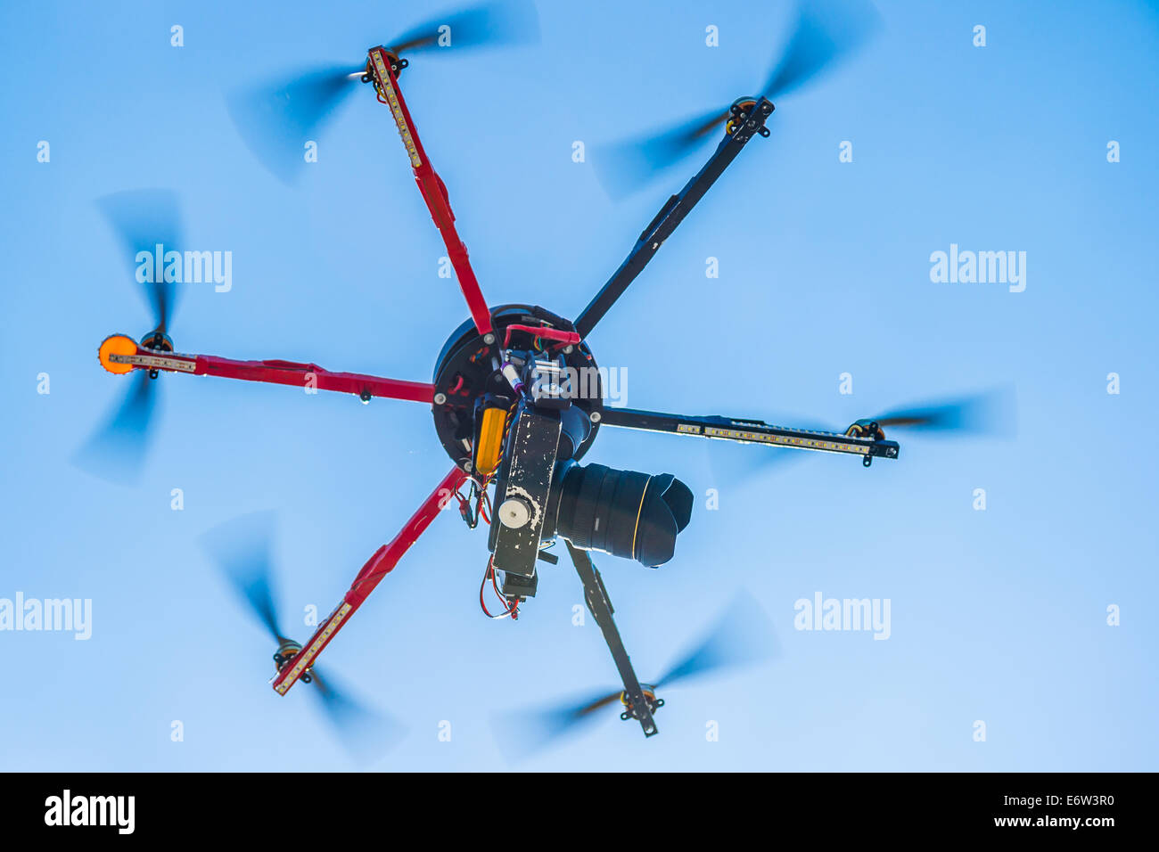 Vista ingrandita di un hexacopter con foto telecamera attaccata in volo Foto Stock
