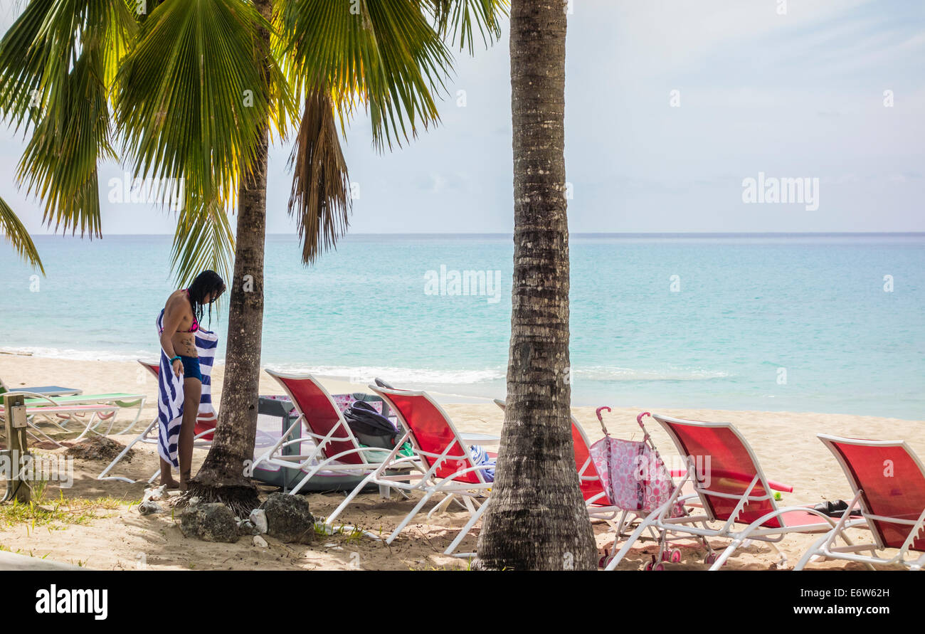 Una donna caucasica con tatuaggi dries off dopo una nuotata nel mare Caraibi sull isola di St. Croix, U. S. Isole Vergini. Foto Stock