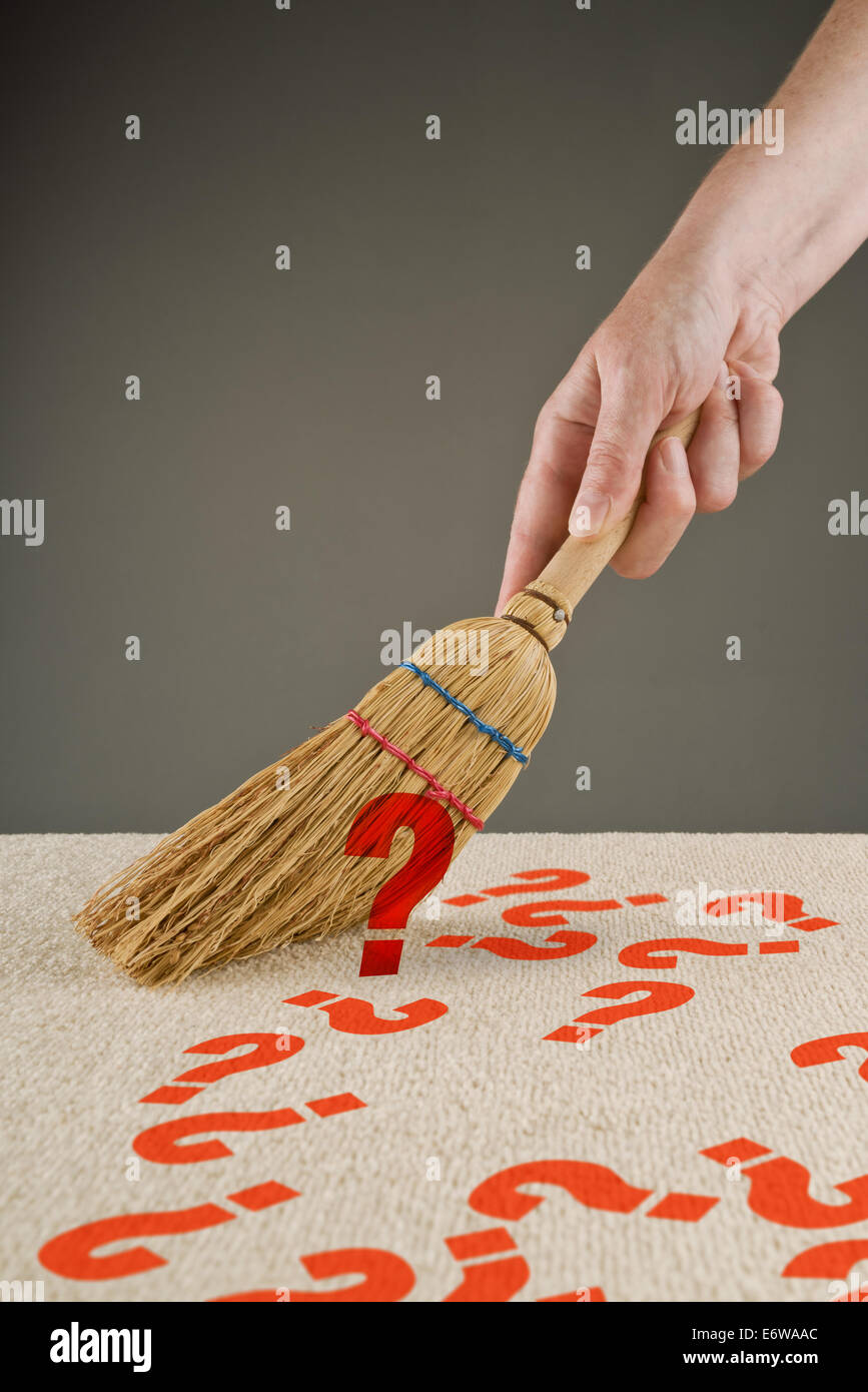 Spazzamento a mano i punti interrogativi da pavimento con piccola scopa Foto Stock