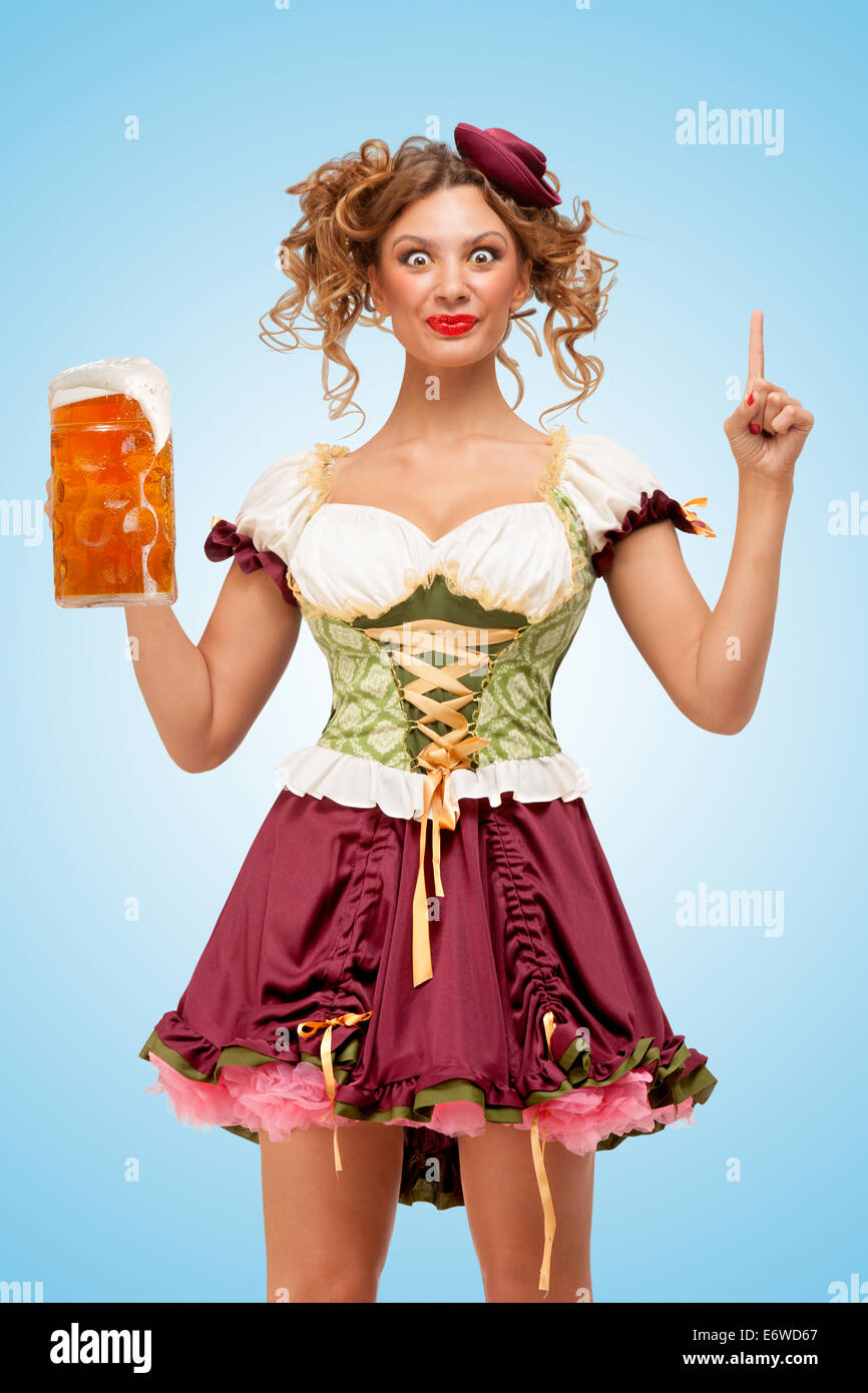 Bella donna che indossa un vestito tradizionale costume per l'Oktoberfest  che serve birra Foto stock - Alamy