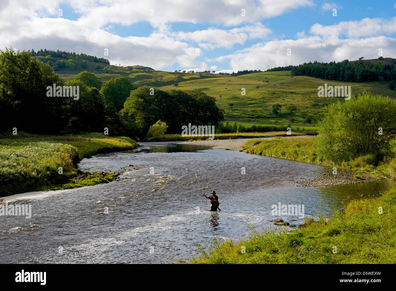 Il pescatore pesca nel Fiume Wharfe vicino Grassington, Wharfedale, Yorkshire Dales National Park, North Yorkshire, Inghilterra, Regno Unito Foto Stock