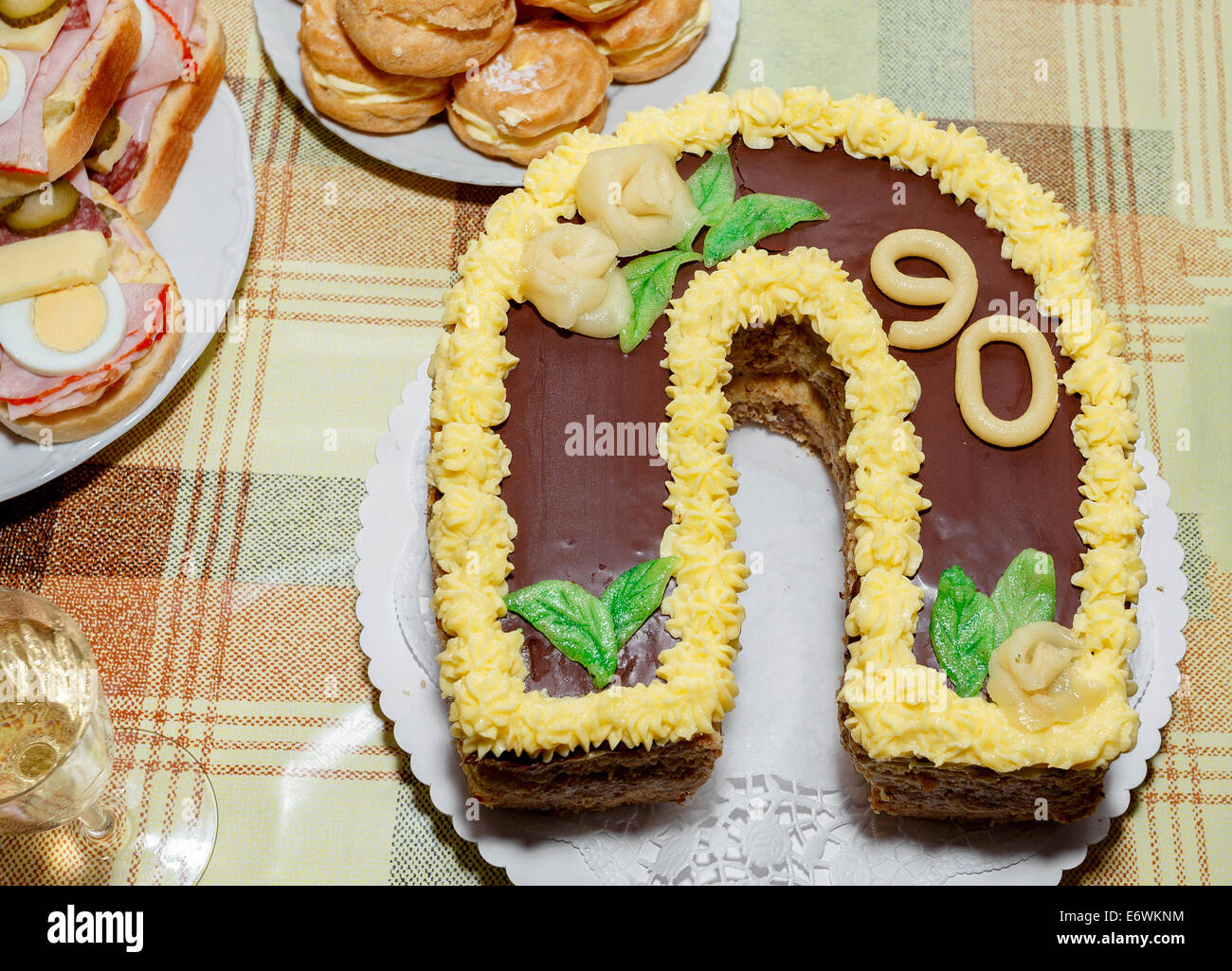 In casa torta di compleanno per novanta anniversario con altri snack sulla scrivania Foto Stock