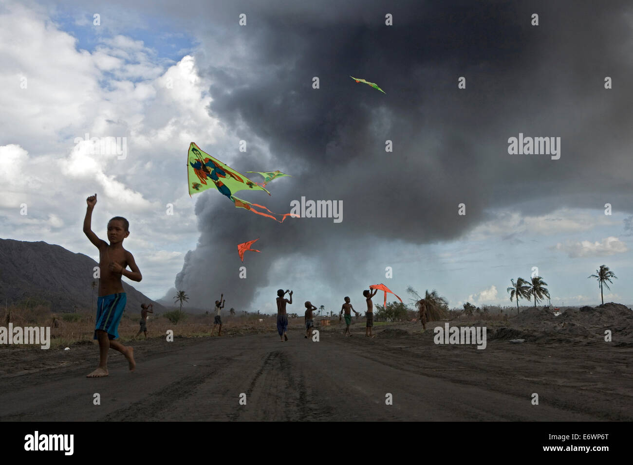I bambini a giocare con aquiloni nelle ceneri vulcaniche, Vulcano Tavurvur, Rabaul, East New Britain, Papua Nuova Guinea, Pacific Foto Stock