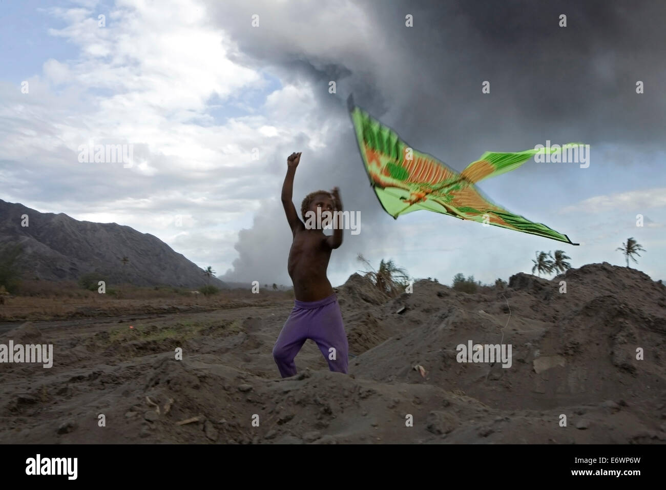 Bambini che giocano con aquiloni nelle ceneri vulcaniche, Vulcano Tavurvur, Rabaul, East New Britain, Papua Nuova Guinea, Pacific Foto Stock