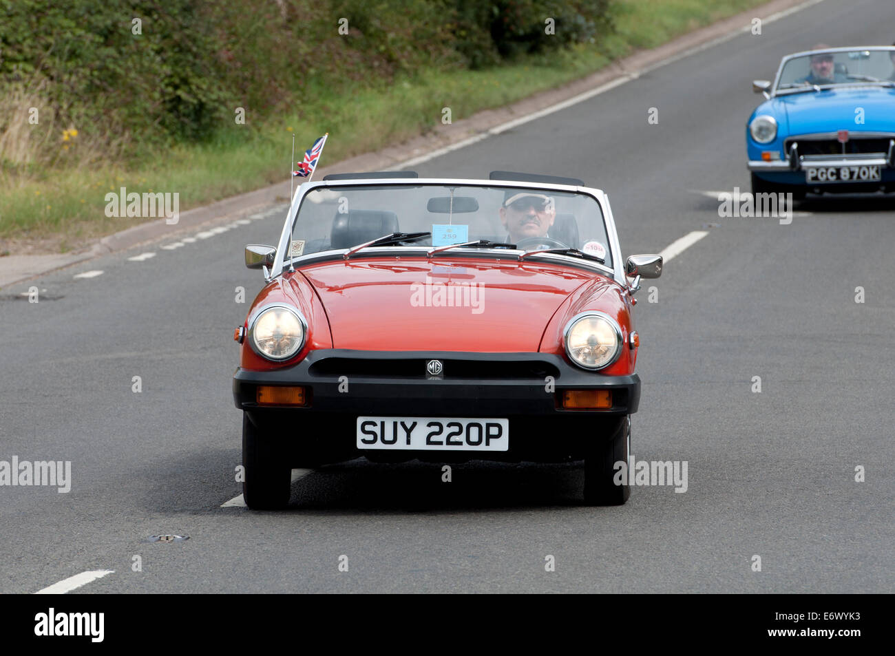 Una guida a sinistra MG Midget auto su Fosse Way road, Warwickshire, Regno Unito Foto Stock