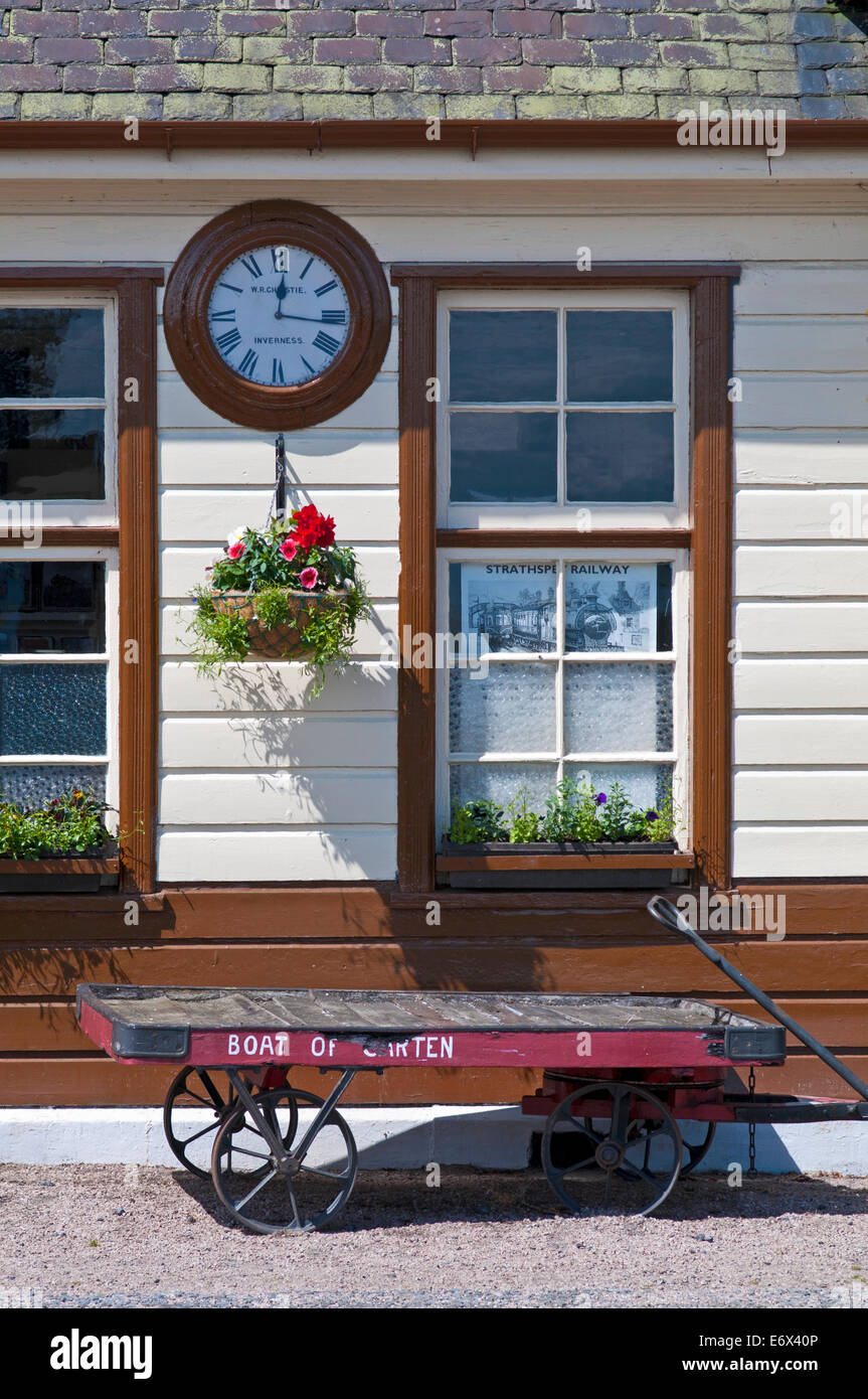 Orologio vintage e carrello bagagli su piattaforma in Boat of Garten vicina, Strathspey Steam Railway, vicino a Aviemore, Cairngorms Foto Stock