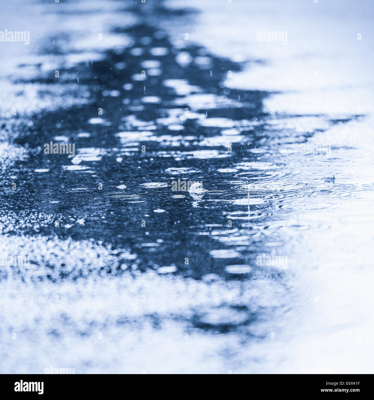 Close up pozza d'acqua con gocce di pioggia caduta Foto Stock