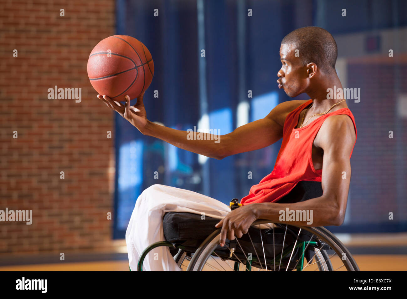 L'uomo con la meningite spinale in carrozzella giocare a basket Foto Stock