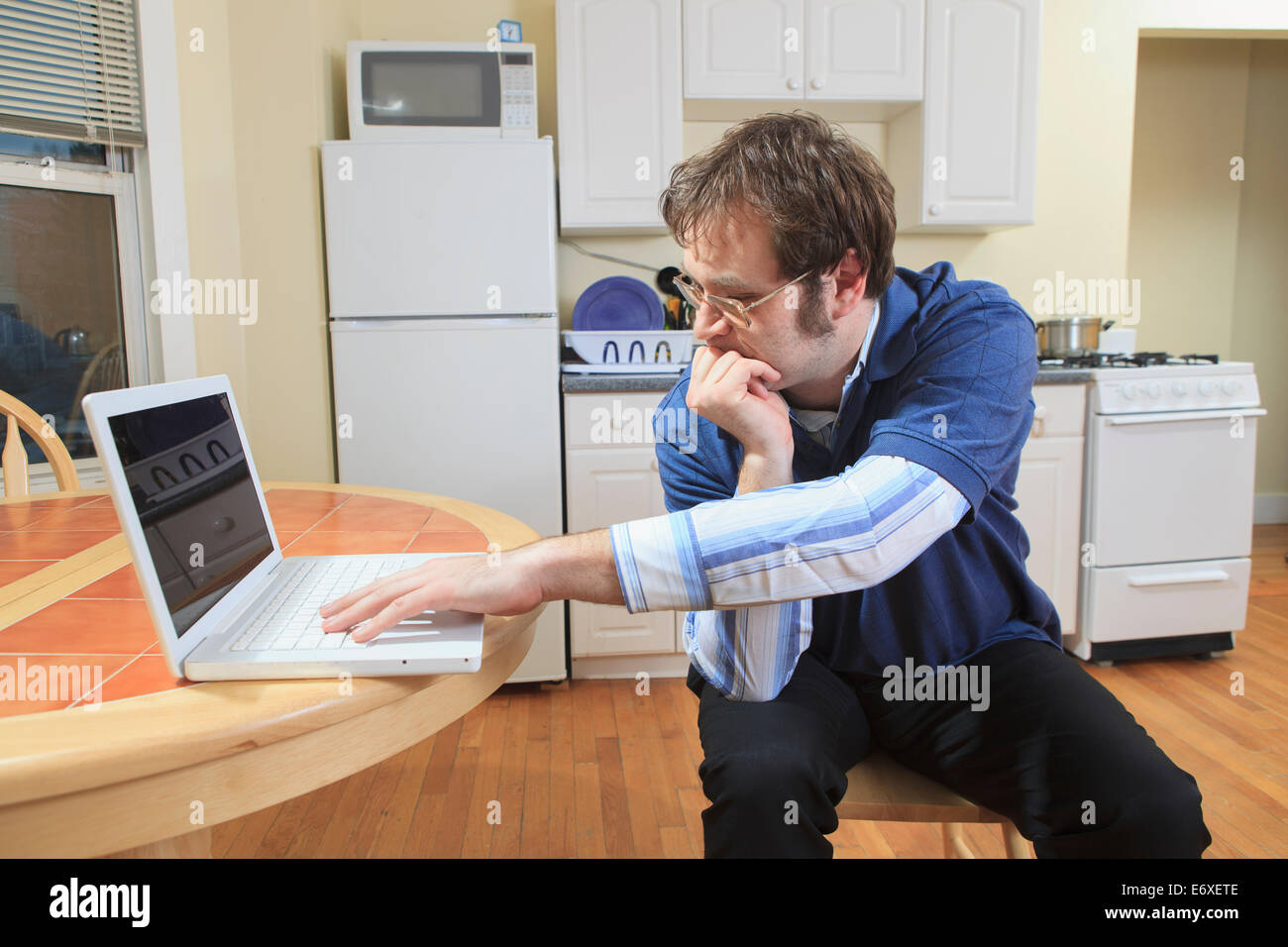 La tecnologia e l'ingegnere programmatore con Aspergers lavorando sul suo computer portatile da casa Foto Stock