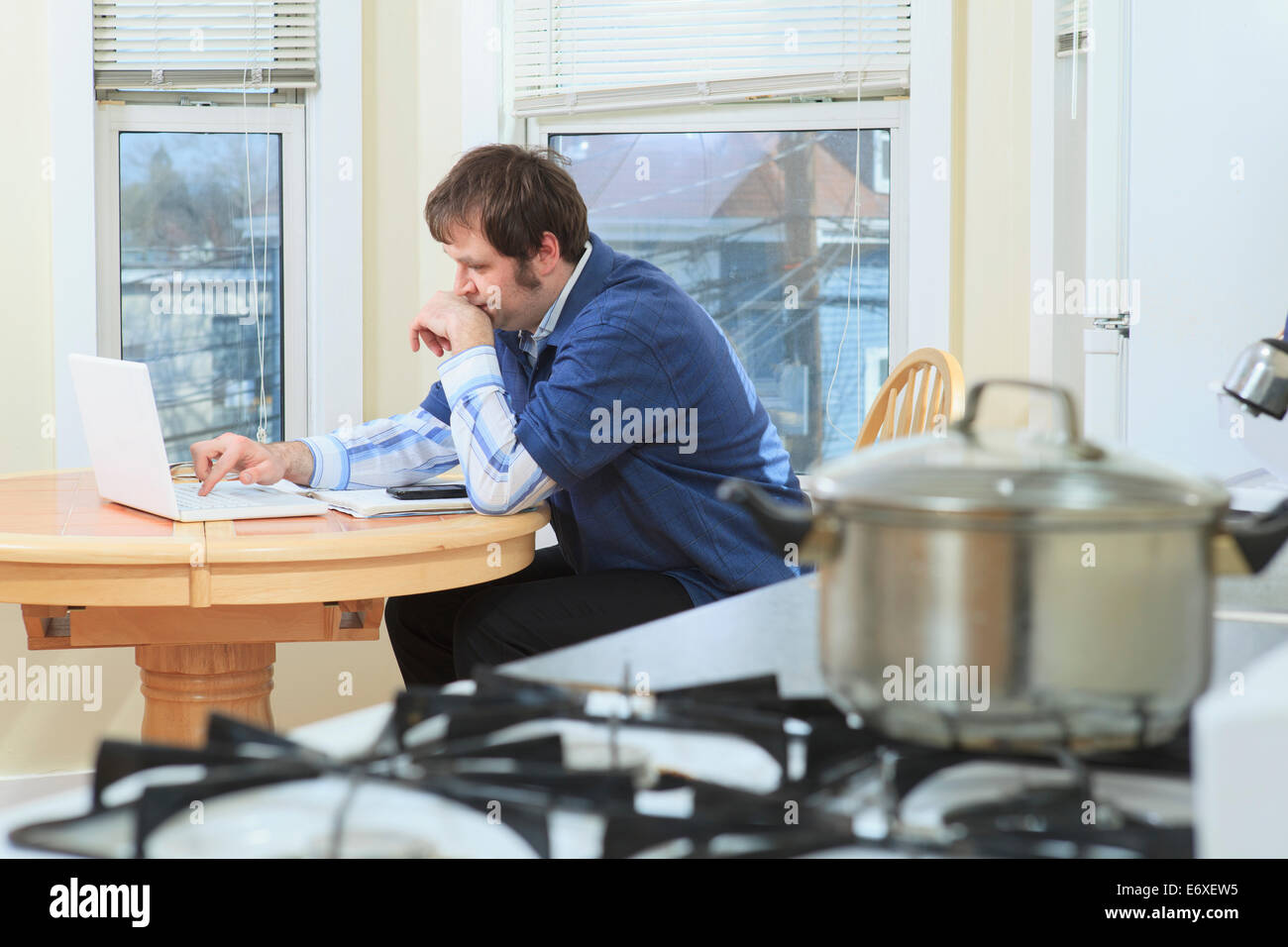 Uomo con Aspergers lavora nella sua casa durante la cottura Foto Stock