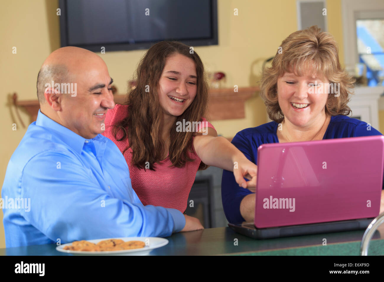 Figlia con il padre e la madre rideva di laptop Foto Stock