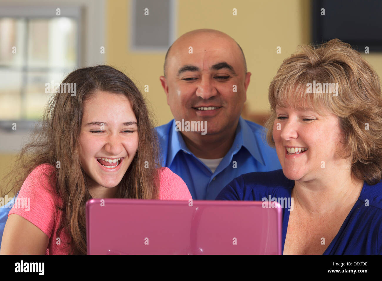 Figlia con il padre e la madre rideva di laptop Foto Stock