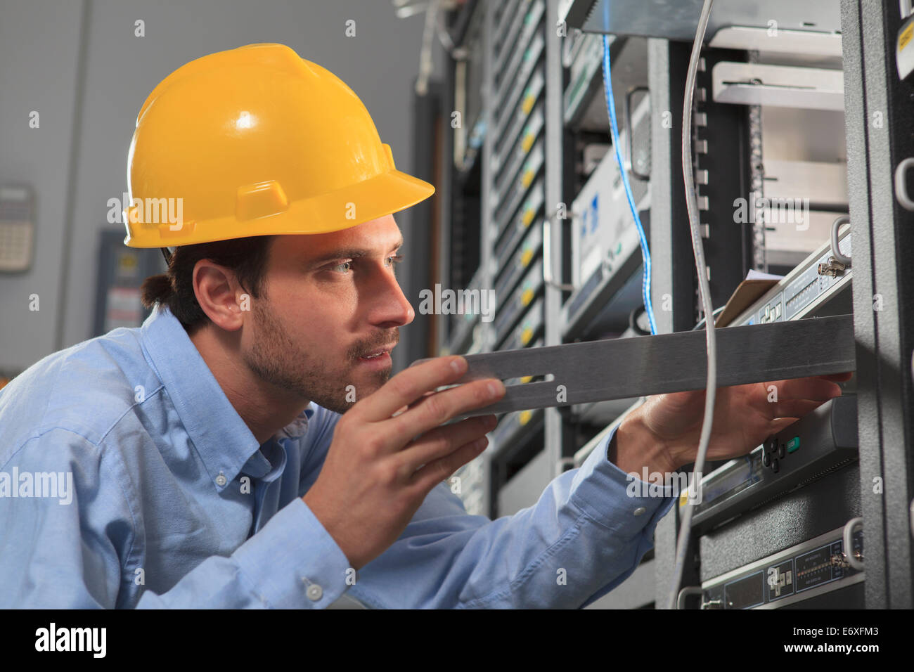 Ingegnere di rete installazione di apparecchiature slitta in rack Foto Stock