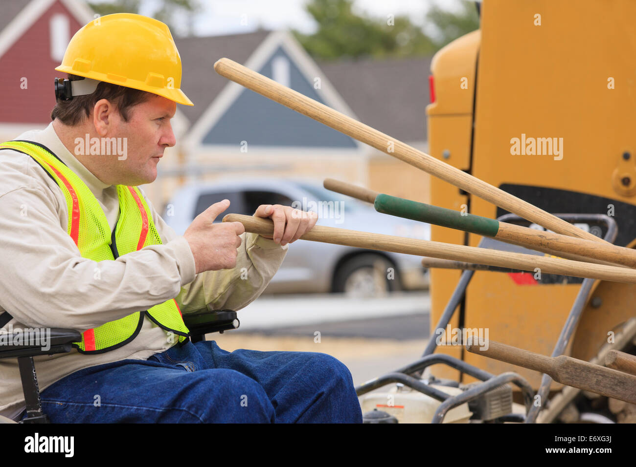 Costruzione supervisore con lesioni del midollo spinale contando gli strumenti di lavoro sul sito in costruzione Foto Stock