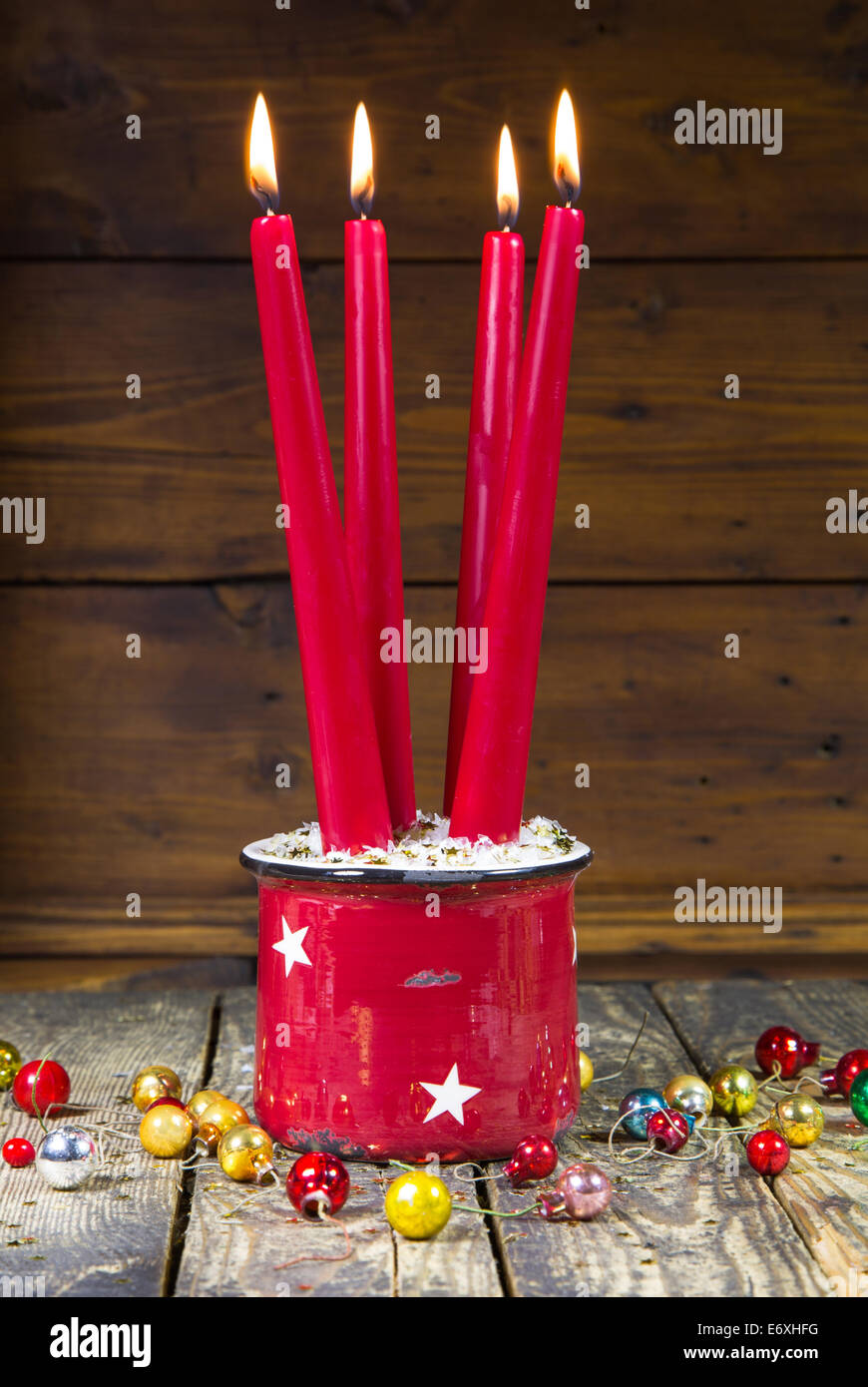 Rosso quattro candele di natale su uno sfondo di legno vecchio con le palle di Natale - vintage o in stile country Foto Stock