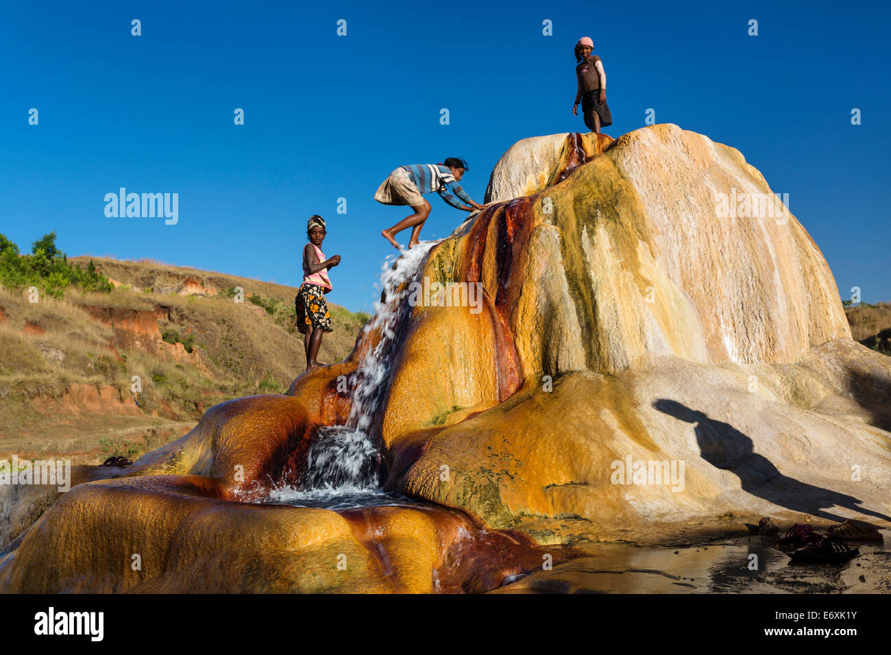 Madagascan bambini che giocano in una schizzando Geyser, geyser di Ampefy, altopiani, Madagascar, Africa Foto Stock