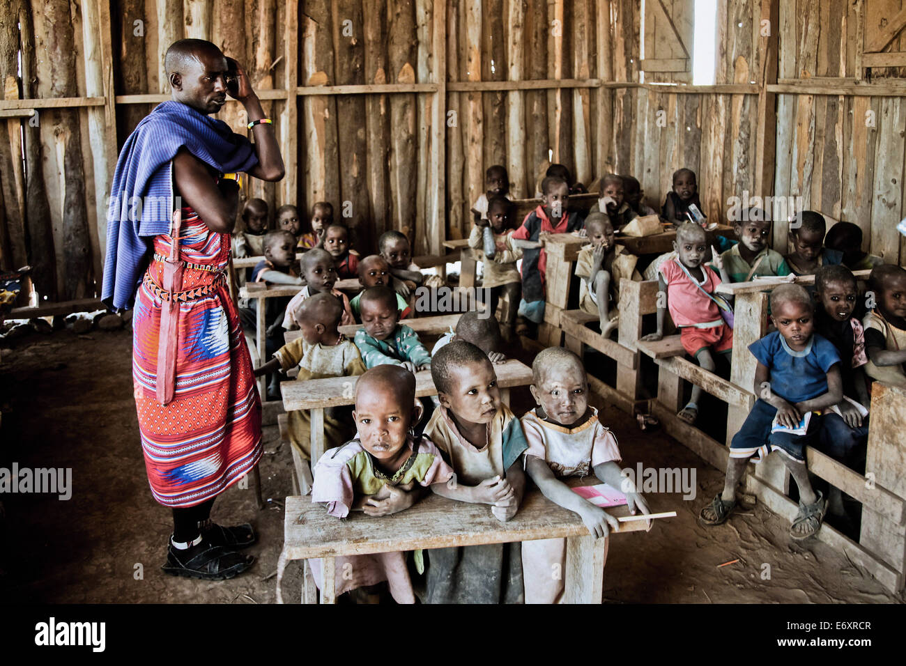 Bambini e insegnante in un Massai scuola di villaggio, Kenya, Africa Foto Stock