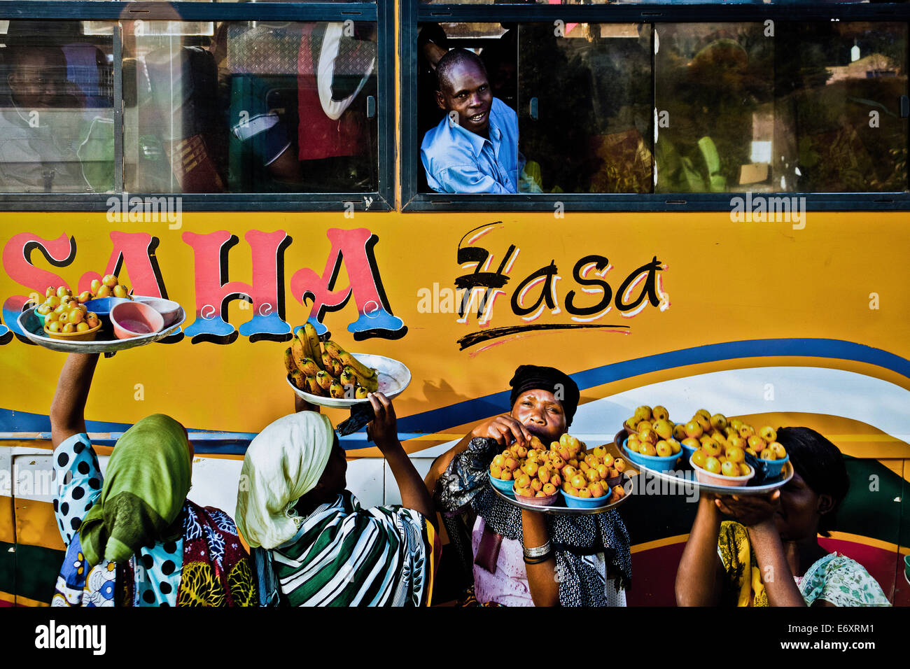 Le donne che vendono frutta ai viaggiatori di bus, Tanzania Africa Foto Stock