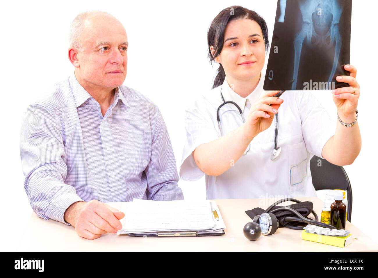 Le donne medico che mostra un'immagine a raggi x per senior uomo paziente. Foto Stock